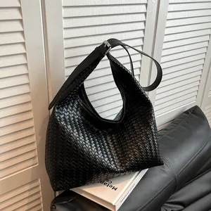 Detail of black woven leather hobo bag with adjustable silver buckle strap