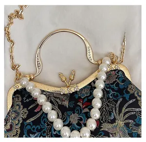 Detail of vintage floral shell bag with beaded handle and diamond-encrusted metal frame