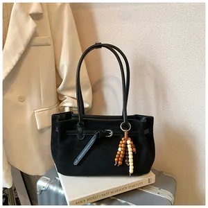 Detailansicht schwarze matte Tragetasche mit Perlenanhänger und Ledergürtelschnalle