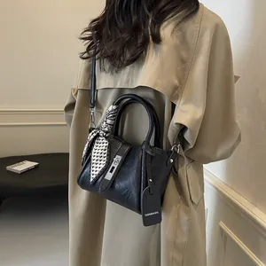 Elegant black leather bucket bag with silk scarf handle and silver hardware detail