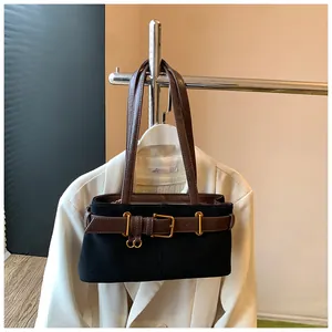 Détail du sac à bandoulière en daim noir avec ceinture en cuir marron et boucle dorée