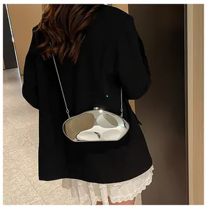 Borsa a tracolla metallica argento irregolare con catena sottile su blazer nero
