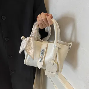 Fashionable cream white bucket bag with silk scarf handle and silver twist lock detail