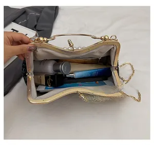 Top view of open metal frame evening bag showing spacious interior with grey lining and pocket