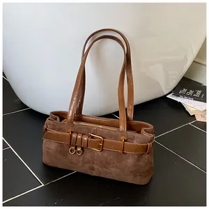 Gros plan détaillé d'un sac d'épaule en daim marron foncé avec boucle de ceinture en métal