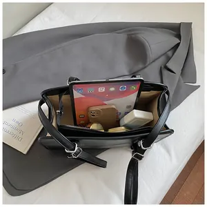 Vue intérieure du grand sac cabas noir montrant les compartiments et les accessoires