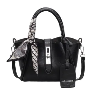 Sac seau en cuir noir avec fermoir argenté et foulard en soie géométrique décoratif