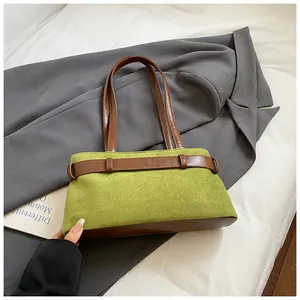 Détail du sac hobo en daim vert avec lanières en cuir marron et boucle décorative