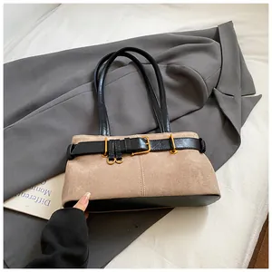 Détail du sac porté épaule en daim beige avec lanières en cuir noir et boucle dorée