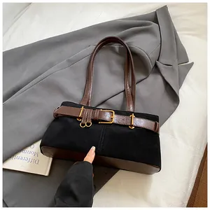 Détail du sac rétro avec finition mate noire et bandoulière à boucle de ceinture brune