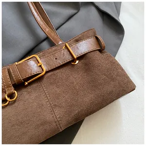 Détail du sac cabas en daim marron avec bandoulière en cuir et boucle en métal doré