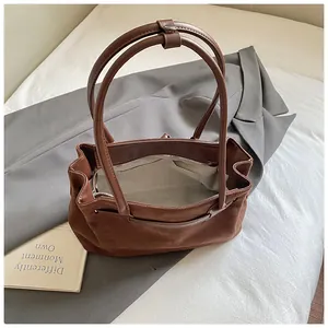 Draufsicht der dunkelbraunen Wildledertasche mit beigem Futter und Reißverschlussfach