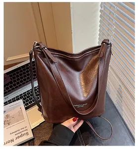 Détail du cabas en cuir ciré marron foncé avec texte mode sur un bureau