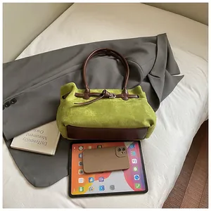 Flachbild von Retro-Wildledertasche in Grün neben Tablet, grauem Blazer und Büchern