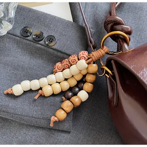 Close-up of bohemian wooden beaded bag charm with retro patterns on dark leather