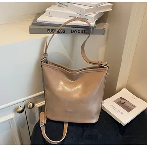 Vue détaillée du sac seau en cuir kaki avec lettrage argenté et doubles bretelles