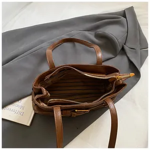 Vue de dessus du sac cabas en cuir marron avec doublure rayée et poche zippée interne