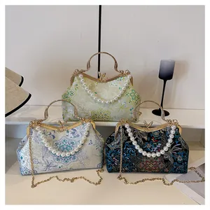 Detailed view of jacquard satin handbags with traditional floral embroidery and pearl handle
