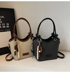 Détail de sacs seaux élégants avec glands en perles de bois et finitions en cuir