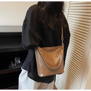 Détail du sac cabas vintage en cuir marron avec anse large et logo gravé dessus