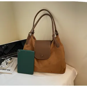 Brown suede tote bag detail with tablet and gadgets for a modern work style