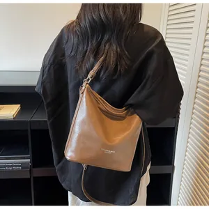 Détail du sac cabas marron vintage avec texture en cuir ciré et logo imprimé