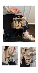 Détail de broderie vintage et fermoir perle sur sac de soirée de style chinois