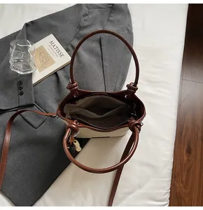 Détail du sac seau en toile avec poignées en cuir marron et poche intérieure zippée