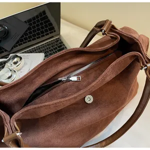 Detail view of the large brown suede tote bag with magnetic closure and inner zip pocket