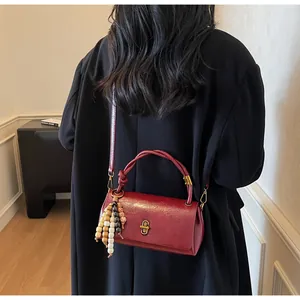 Deep red vintage oil wax leather handbag with bead tassel and metallic turn-lock detail