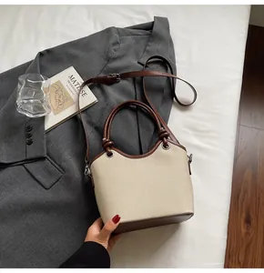 Sac seau en toile chic avec garniture en cuir marron et livre d'art sur blazer gris