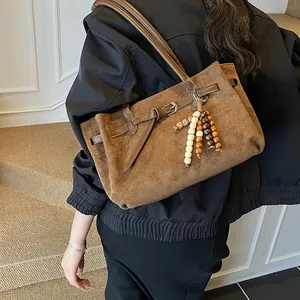 Braune Vintage-Tasche aus Wildleder mit Perlenanhänger und stilvollen Schnallen