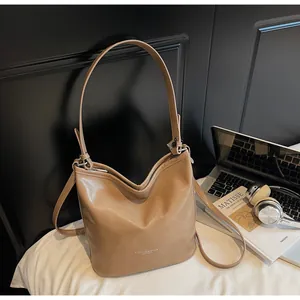 Vue détaillée du sac cabas marron avec logo blanc sur une surface de sac seau épuré