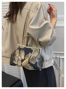 Détail du sac à main brodé de fleurs vintage avec bordure en cristal et fermoir perle