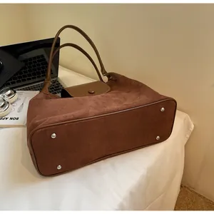 Detailed base view of dark brown nubuck tote bag with silver protective metal feet