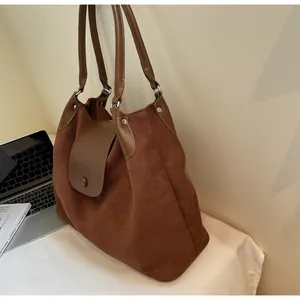 Detail of soft matte leather tote bag with metallic rivet and magnetic snap closure