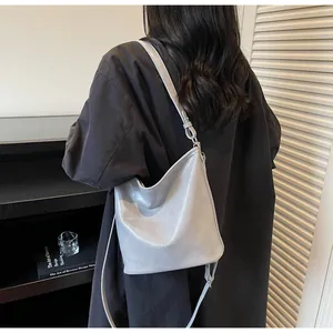 Mannequin portant un sac cabas minimaliste en cuir gris clair dans un intérieur