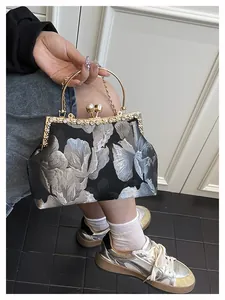 Détail du sac à main jacquard floral vintage avec fermoir baiser et perles élégantes