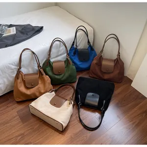 Top view of large matte tote bags in six colors arranged on a dark wooden floor