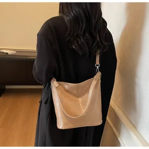 Détail du sac cabas en cuir kaki sur modèle montrant la capacité et la bandoulière