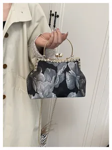 Détail d'un sac brodé vintage avec fermoir perle et poignée en anneau doré chic