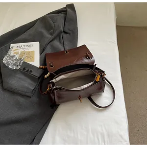 Overhead view of amber brown faux leather shoulder bag with vintage magnetic flap and beads