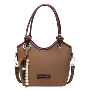 Sac seau texturé marron avec anses en cuir et breloque décorative en perles