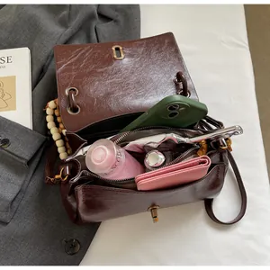 Detail view of large interior capacity and zipper pocket of brown oil wax leather bag