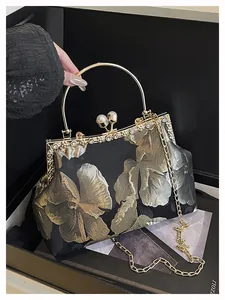 Détail du sac de soirée en brocart brodé avec fermoir perle et poignée anneau doré en coffret
