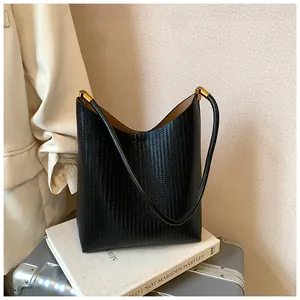 Détail d'un élégant sac hobo en cuir tressé noir avec des garnitures métalliques dorées
