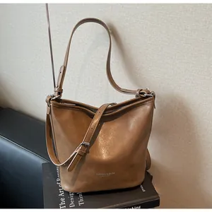Vue détaillée du sac cabas en cuir marron avec lettrage argenté et bandoulière
