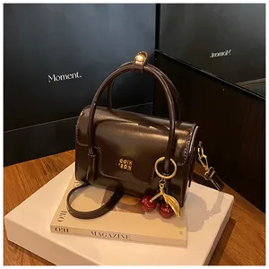 Deep brown glossy leather mini square handbag with gold logo and cherry charm detail
