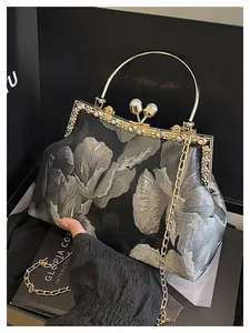 Détails de broderie florale sur sac de soirée avec fermoir doré et ornements perles
