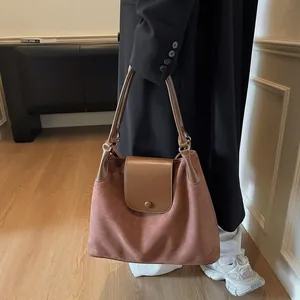 Detail of suede leather tote bag showing vintage caramel texture and flip magnetic closure